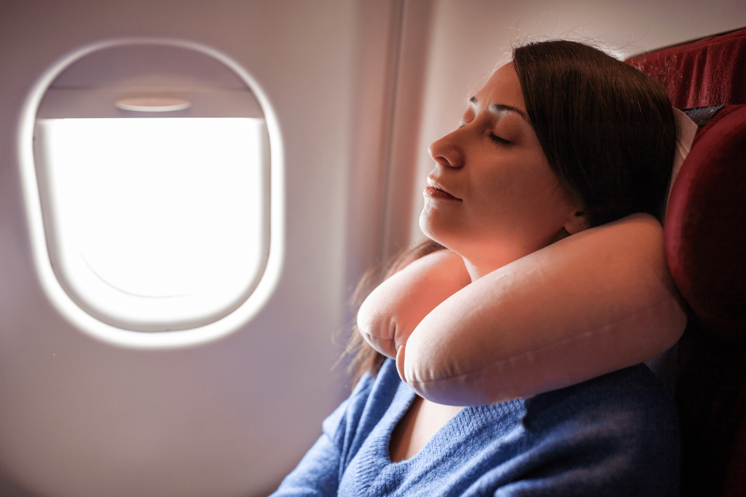 Women sleeping on the plain with neck pillow