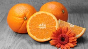 Apelsinid laual koos oranzi gerbera õiega