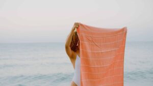 Naine hoiab mererannas rannalinna enda näo ees